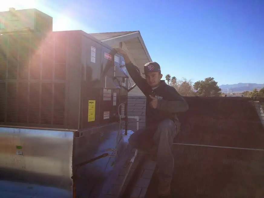 HVAC technician performing Air Duct Cleaning on a rooftop unit in Kenilworth